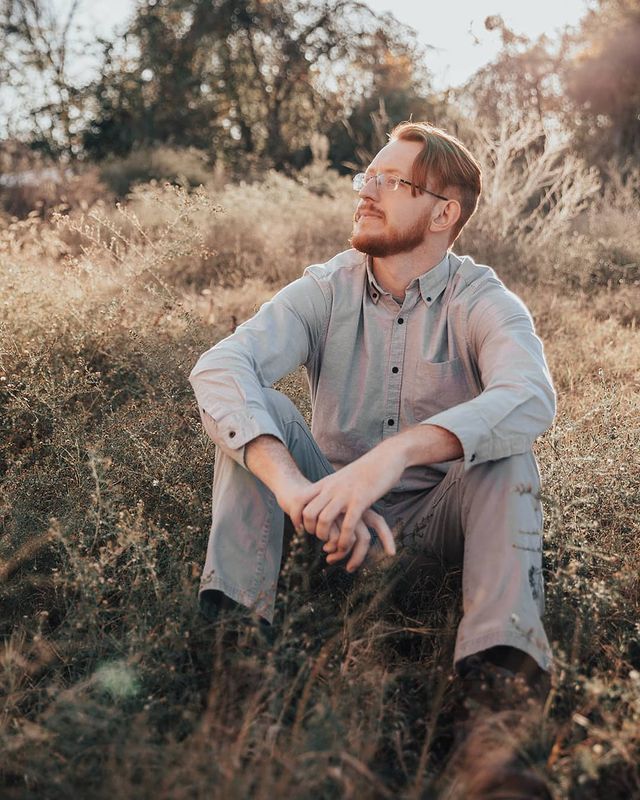 Gunner Vincent Calaway in a grey shirt and pant posing in a peaceful environment.